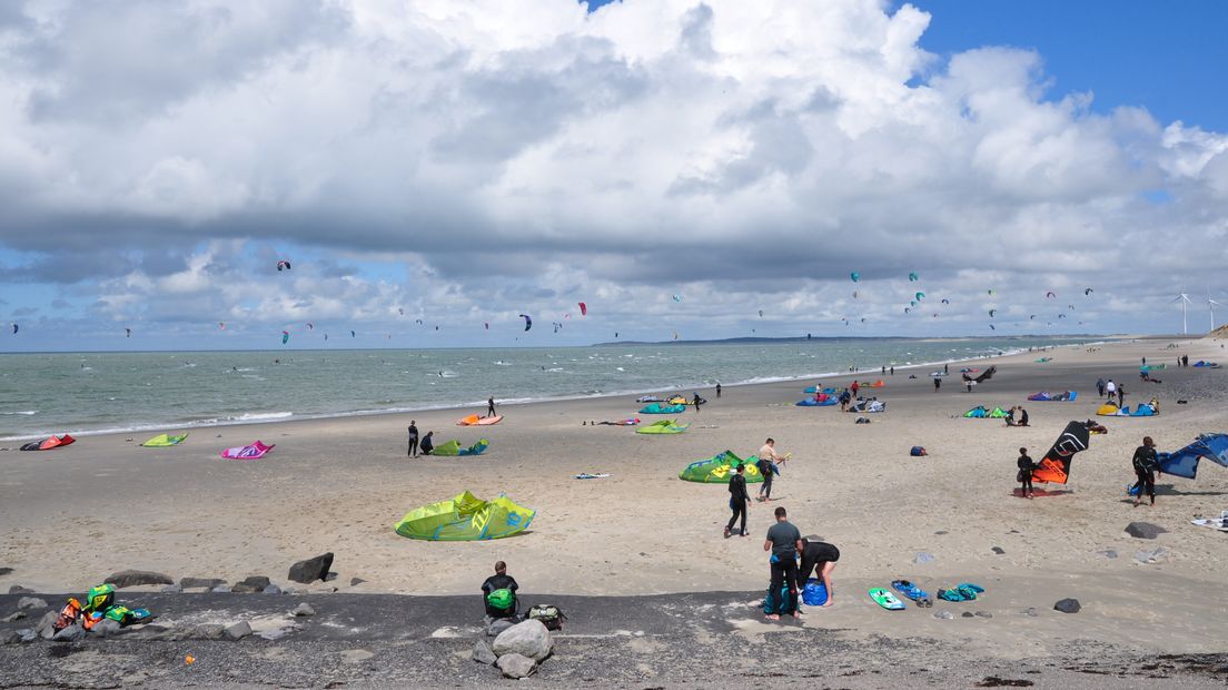 Kitesurfers vermaken zich op het strand van Neeltje Jans