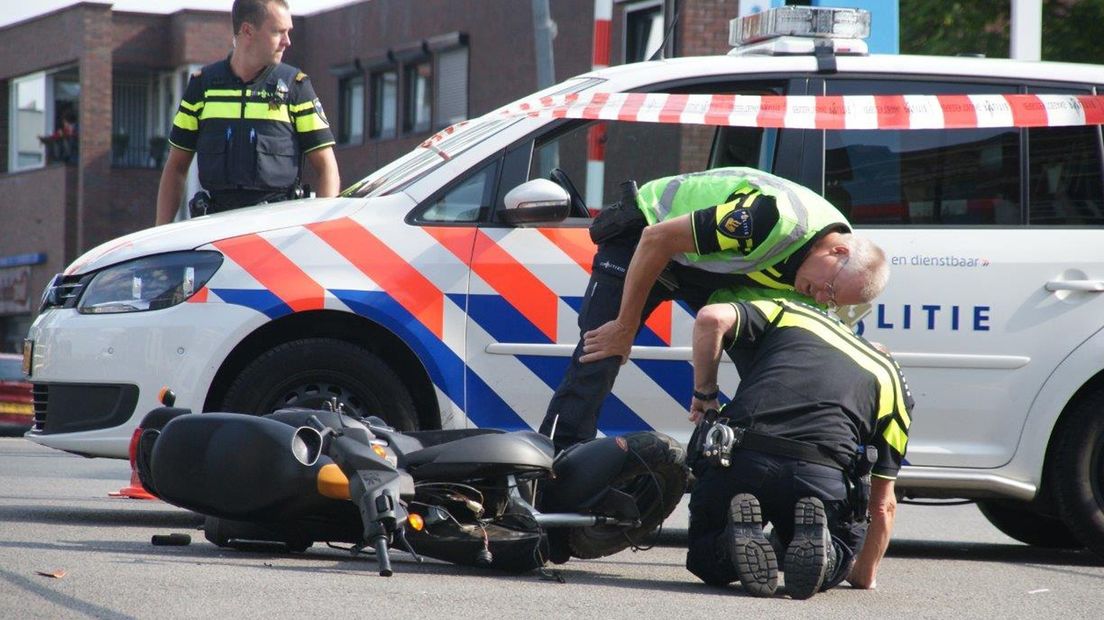 Agenten inspecteren de gebotste scooter.