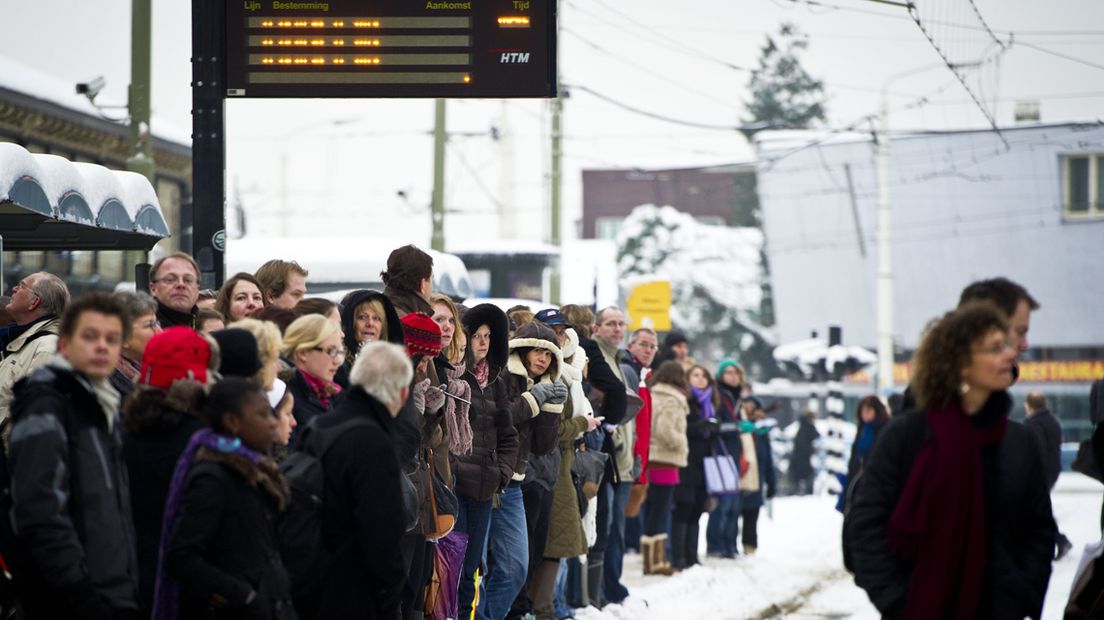 Wachtende mensen bij tramhalte in de sneeuw