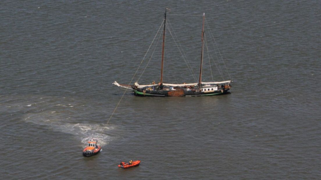 Vastgelopen zeilcharter Isis krijgt hulp van reddingboten, gefotografeerd vanuit het Kustwachtvliegtuig