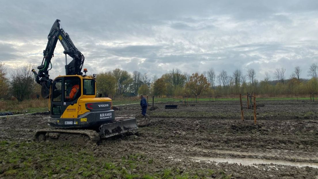 Met hulp van een graafmachine worden de fruitbomen bij Rusthoven geplaatst