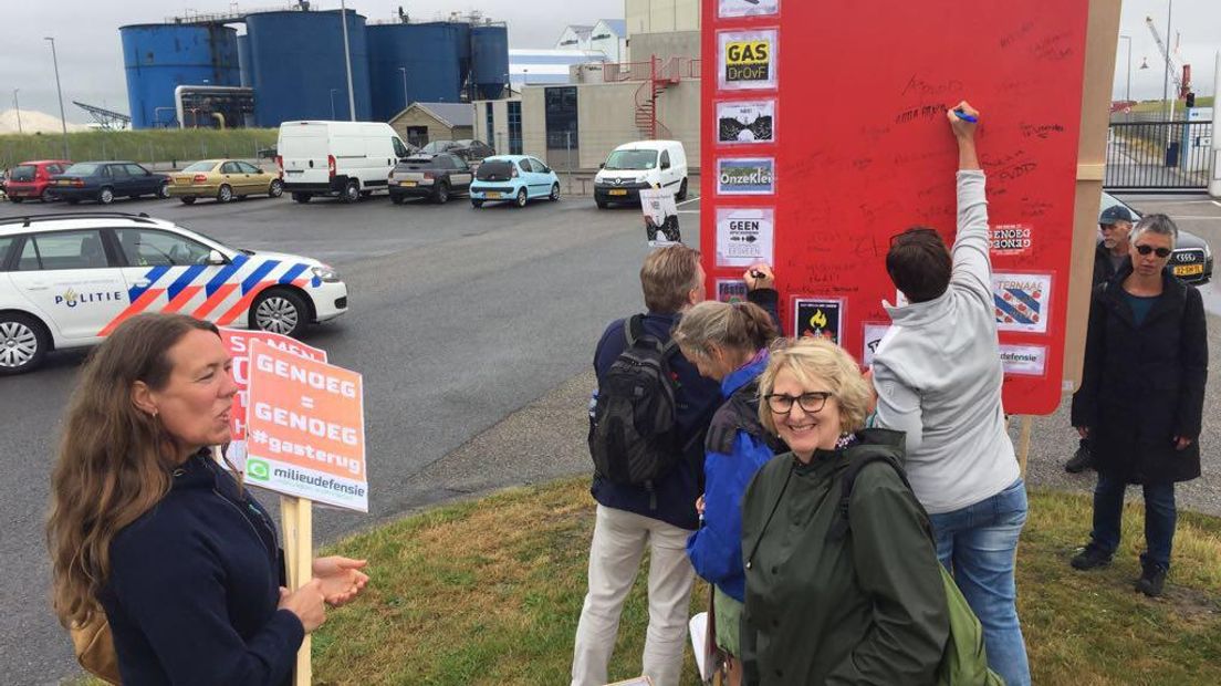 Demonstranten delen een rode kaart uit voor Vermilion (Rechten: Jeannette van der Velde)