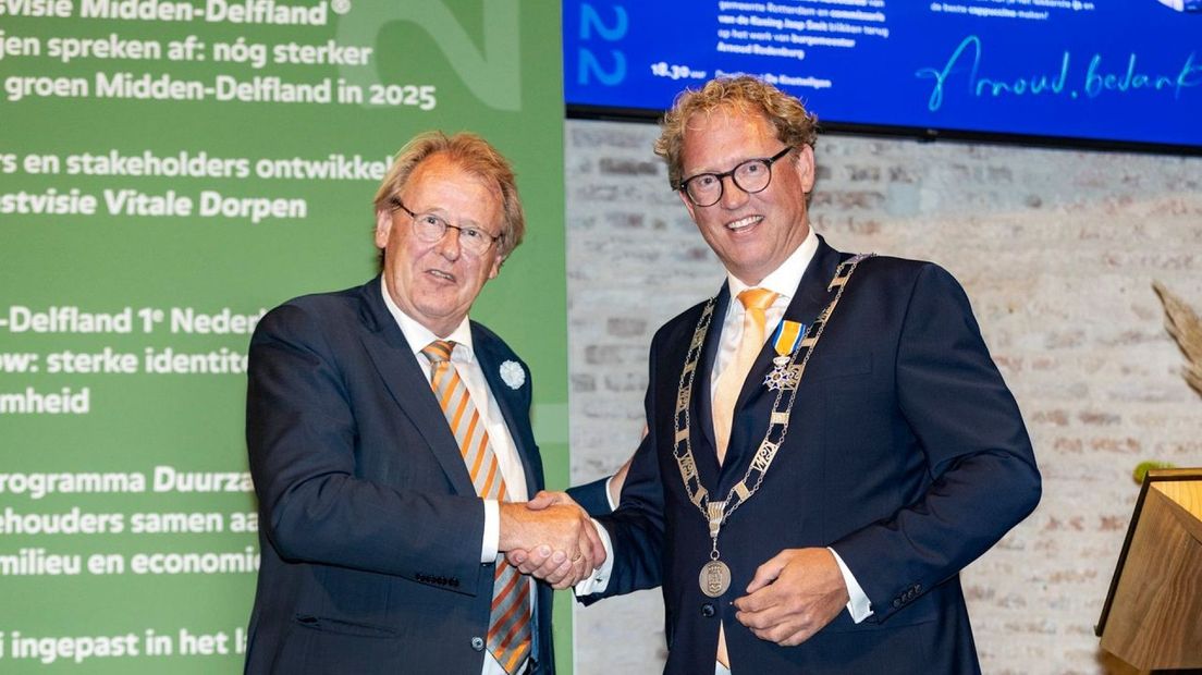 Burgemeester Arnoud Rodenburg wordt gefeliciteerd door commissaris Jaap Smit