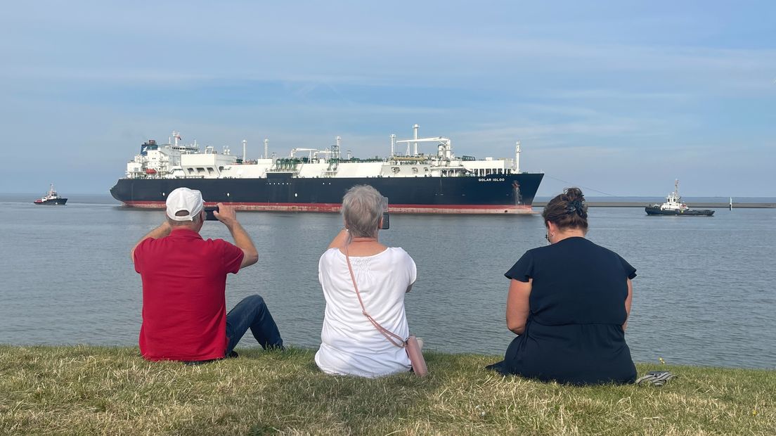 Mensen kijken naar de aankomst van het schip in de Eemshaven