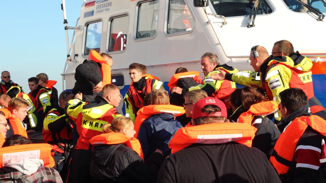 Opvarenden veerboot aan boord van reddingsboot KNRM bij evacuatie-oefening