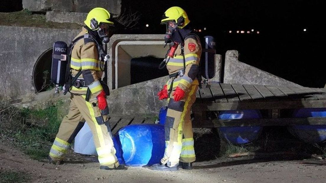 Brandweerlieden staan bij drugsvaten in Nederasselt.