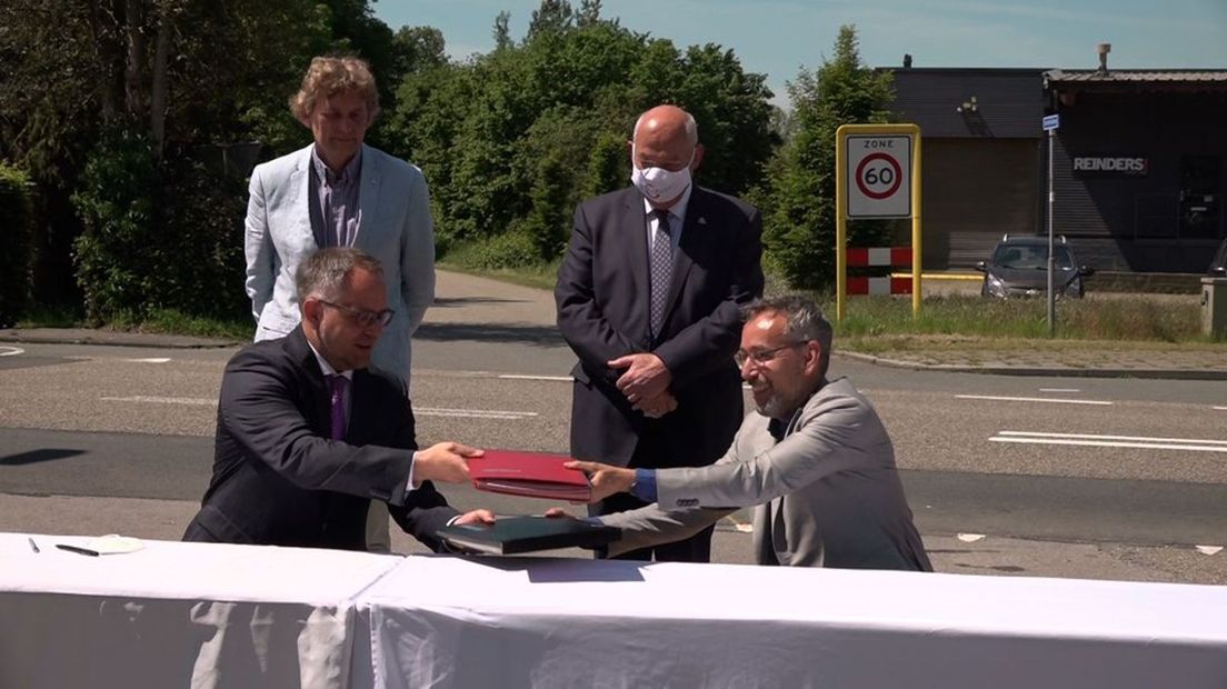 Gedeputeerde Jan van der Meer en burgemeester Kerkhoff van Bocholt ondertekenen de overeenkomst voor de buslijn.