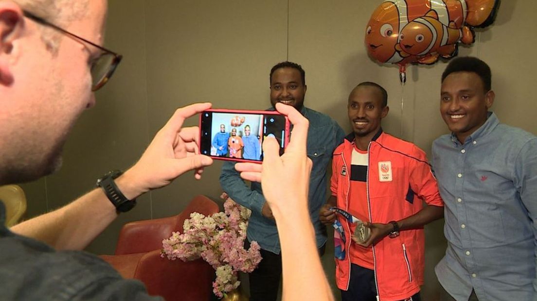 Abdi Nageeye toont met trots zijn zilver aan vrienden.