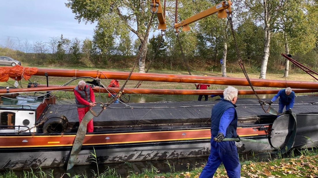 Vrijwilligers helpen bij het optakelen van het turfschip
