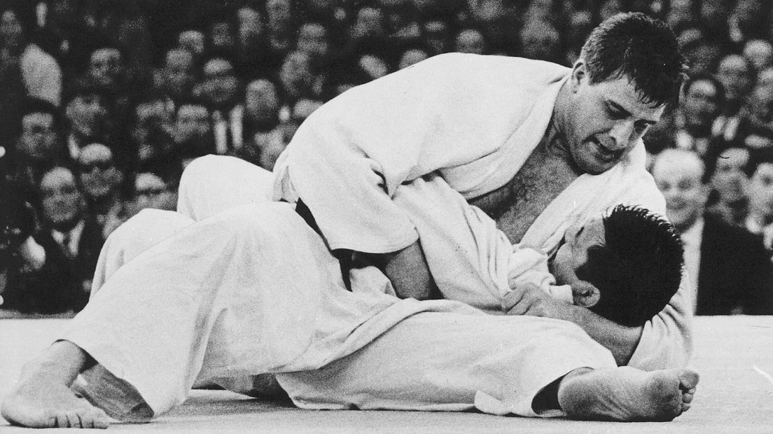 De ijzeren houdgreep van Anton Geesink. Dertig seconden worstelde de Japanner Kaminaga om te ontkomen aan de Nederlander en om Japan de vierde gouden judo-medaille te bezorgen. Het was te vergeefs. Geesink was letterlijk en figuurlijk de sterkste.