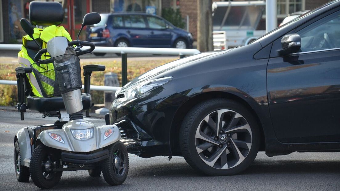 De auto naast de aangereden scootmobiel.