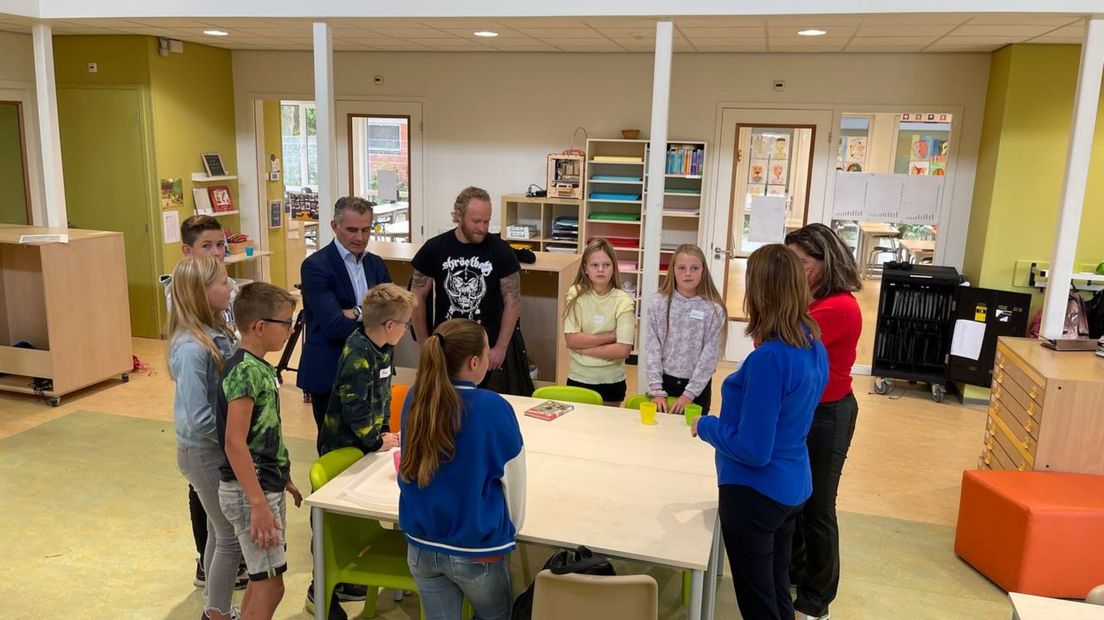 De commissieleden (met links, in pak, Tom van der Lee) in gesprek met leerlingen