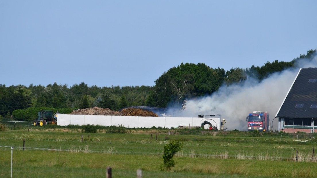 De brand woedt naast de stal die inmiddels is ontruimd