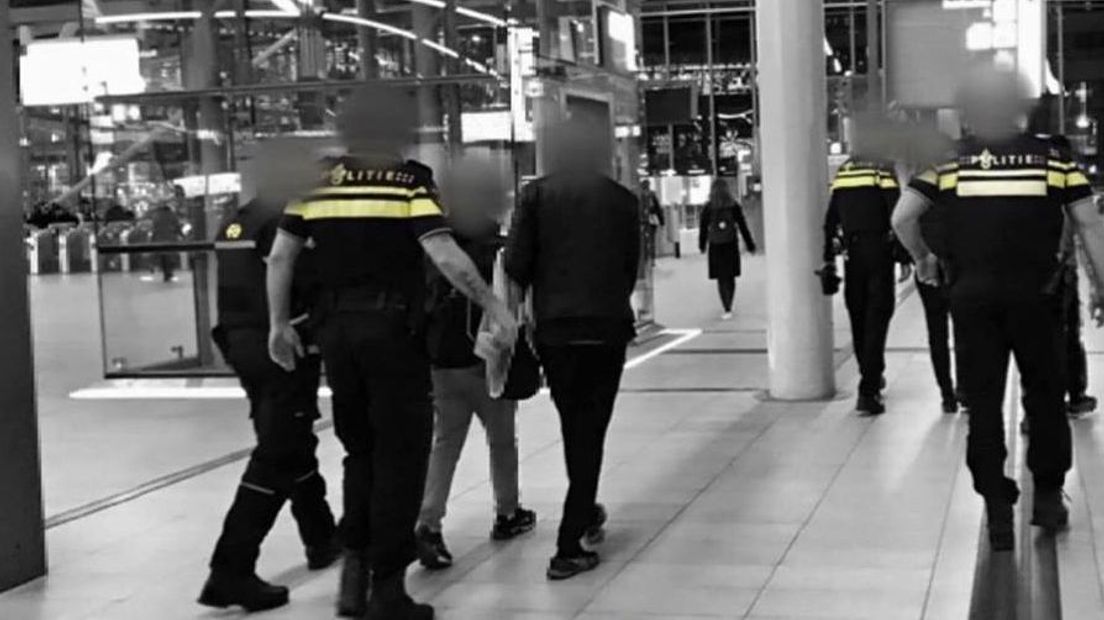 Een van de verdachten wordt afgevoerd op Utrecht Centraal.