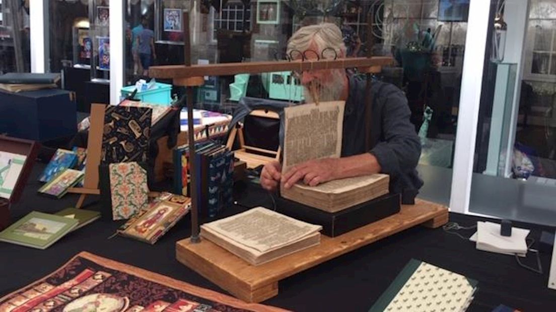 De boekenbinder die bezig is met het binden van een bijbel uit 1250