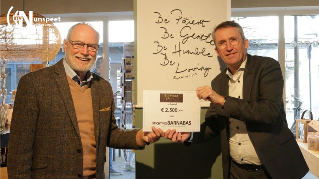 Bert van Varwijk (links) van Stichting Barnabas neemt de cheque aan.