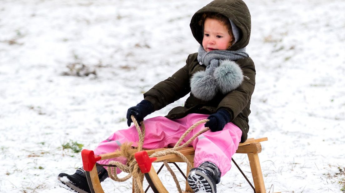 Een kind geniet van de sneeuw
