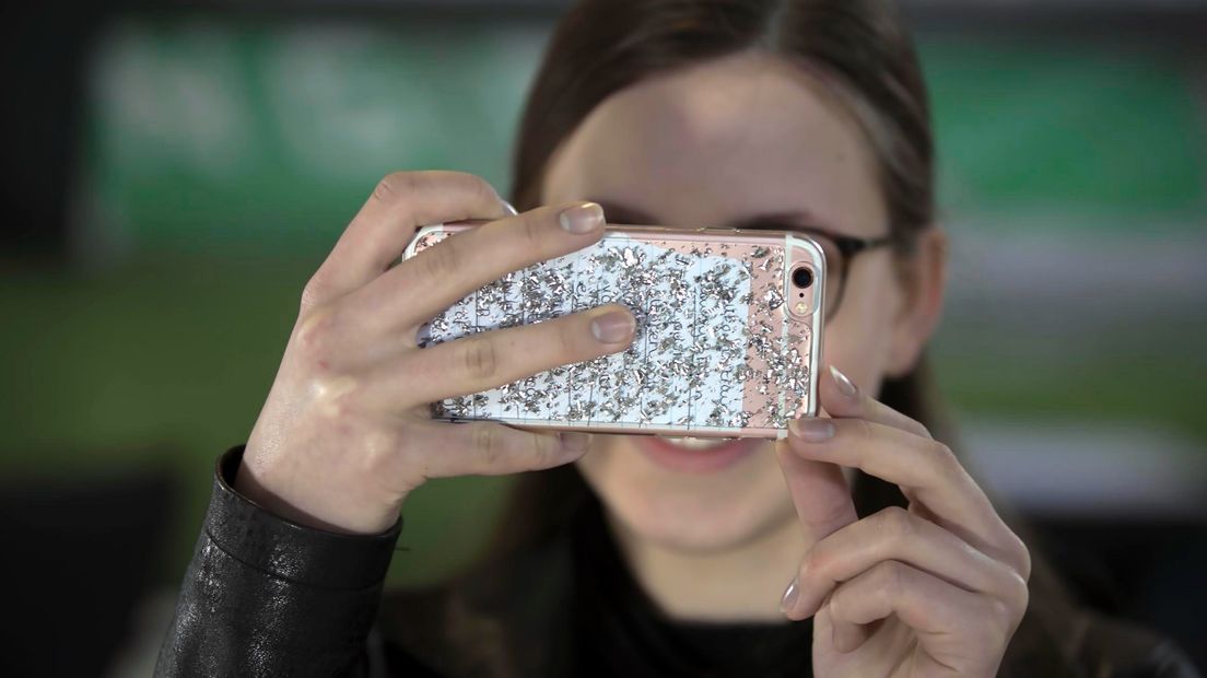 Een meisje kijkt op haar mobiele telefoon