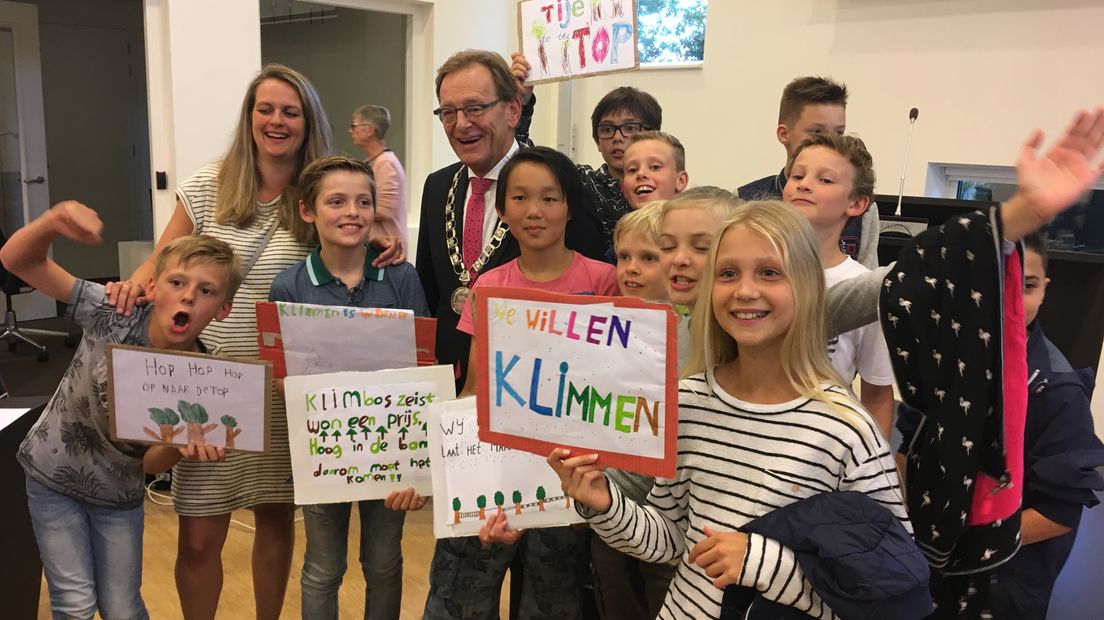 Burgemeester Janssen temidden van blije kinderen.