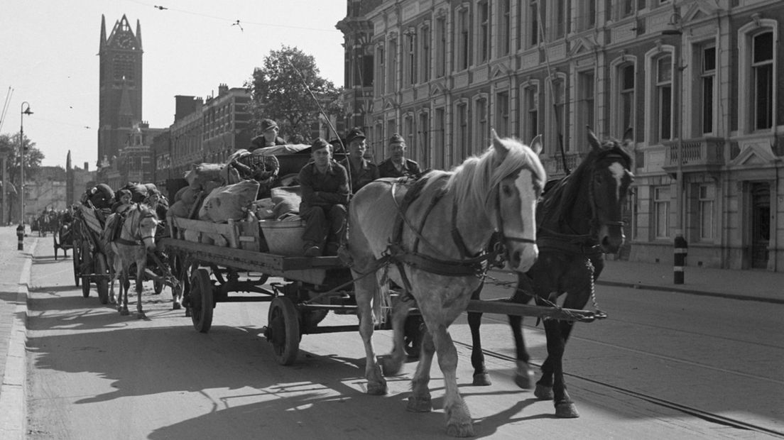 Duitse krijgsgevangen met alleen nog persoonlijke bezittingen, worden met paard en wagen uit Den Haag afgevoerd.