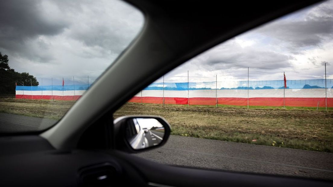 Een grote omgekeerde Nederlandse vlag langs de A1 in Stroe