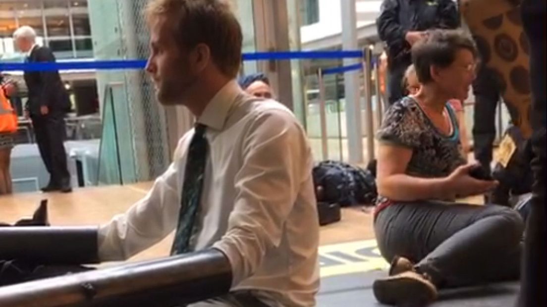 Demonstranten zijn geketend aan een pilaar