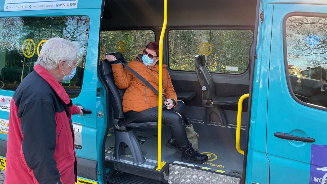 Een passagier stapt in de bus van Stichting Ouderenvervoer Norg