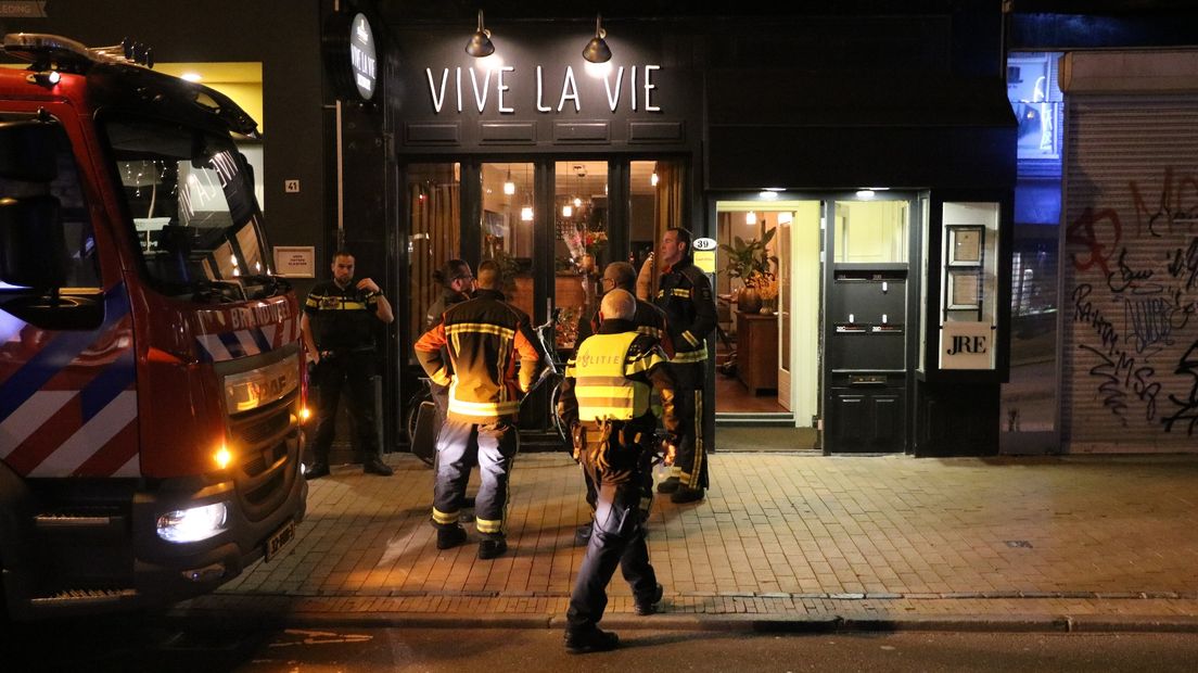 Brandweerlieden bij het restaurant in de Oosterstraat, waar het gaslek werd waargenomen