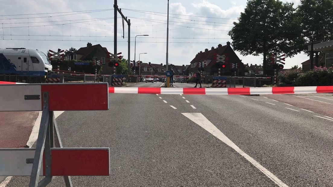 Spoorwegovergang afgezet met linten en borden
