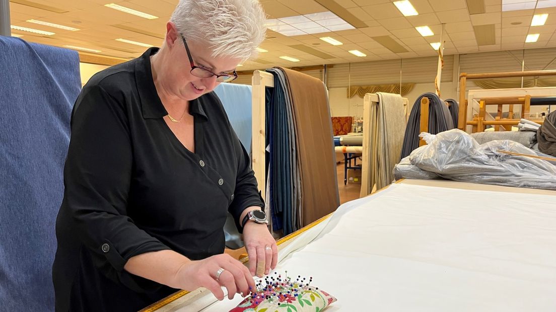 Een medewerkster aan het werk in het gordijnenatelier