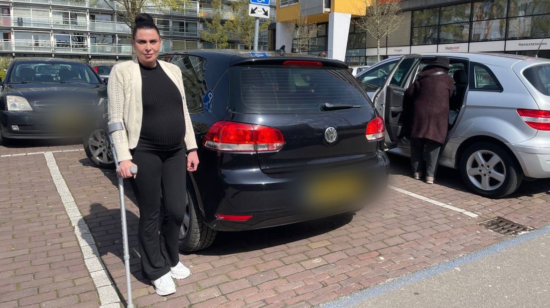 Kristina Anders staat bij haar auto op de gehandicaptenparkeerplaats