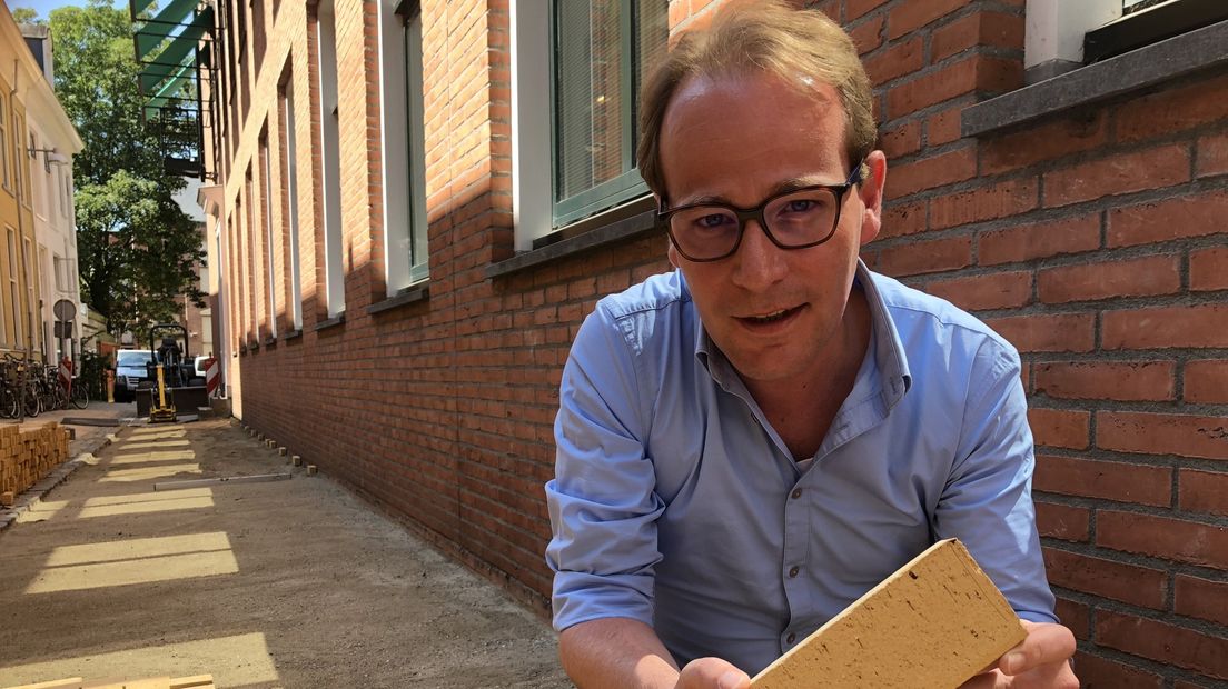 Groninger wethouder Joost van Keulen met een nieuw geel steentje in zijn handen.