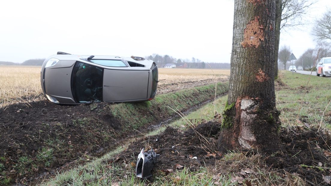 De auto ligt op de kant na de klap