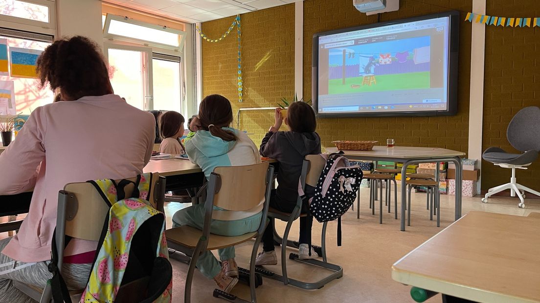 De Oekraïense kinderen kijken naar filmpjes van Tom & Jerry