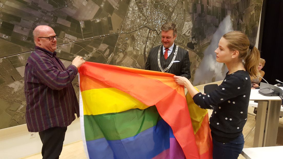 Jerry Stoker (links) en PvdA'er Nina Jasperse ontvouwden vorig jaar de regenboogvlag.