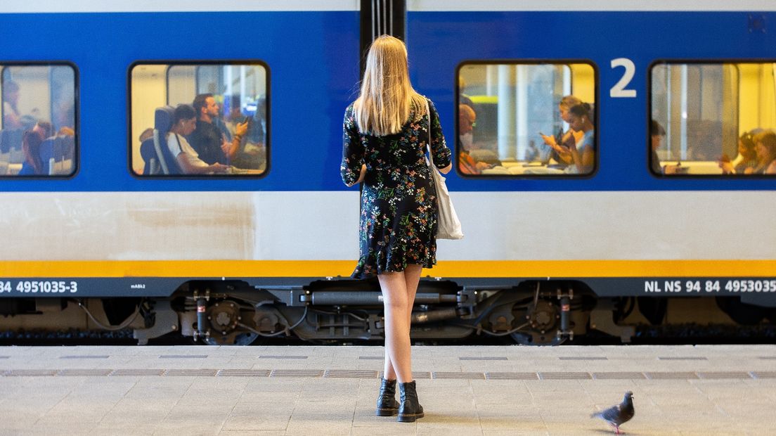 Een willekeurige vrouw wacht op het perron op de trein