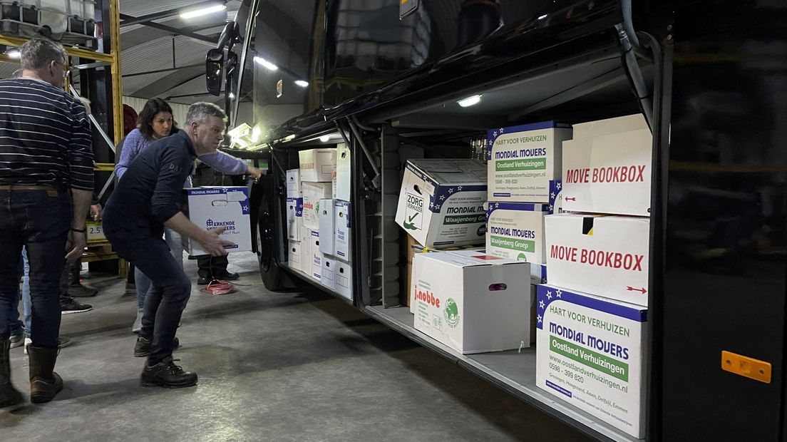 Vrijwilligers laden dozen met hulpgoederen de bus in
