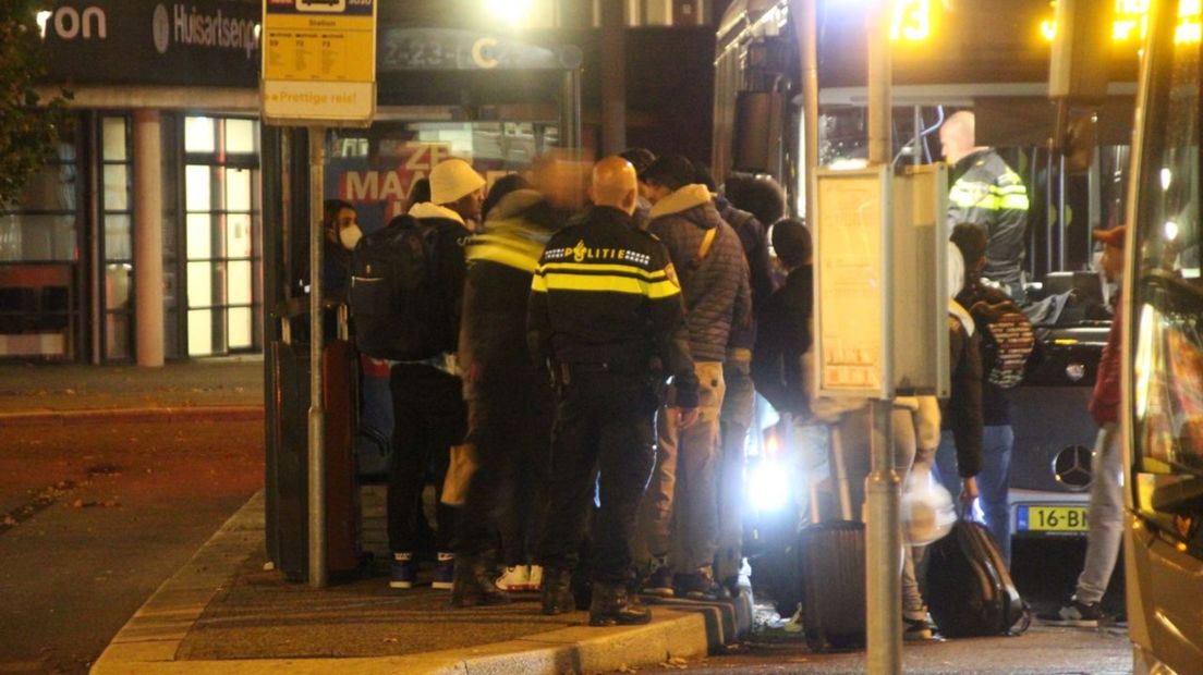 Politie op het busstation van Emmen, bij een groep asielzoekers op weg naar naar Ter Apel