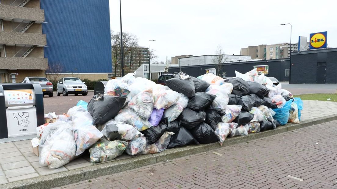 Afvalcontainers in Enschede Zuid, overladen met vuilnis