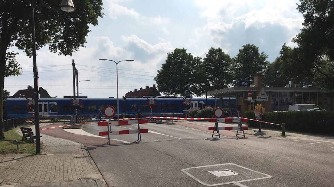 Spoorwegovergang afgezet met linten en borden