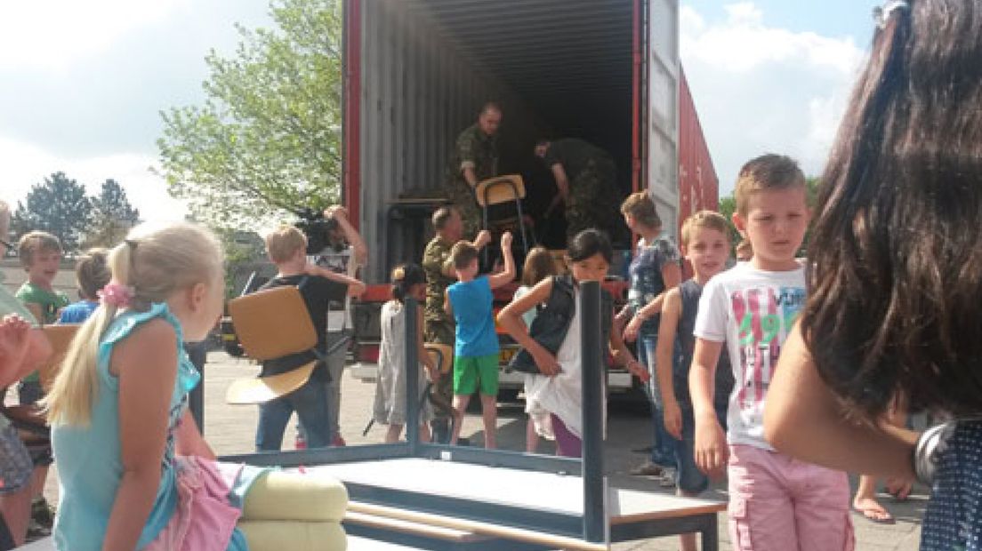 Kinderen van de Koningin Beatrixschool in Nijkerk verhuisden woensdag zelf hun tafels en stoelen naar een container.