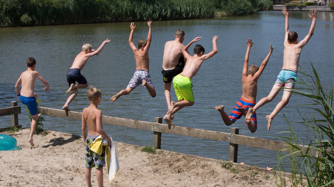 Kinderen springen in het water.