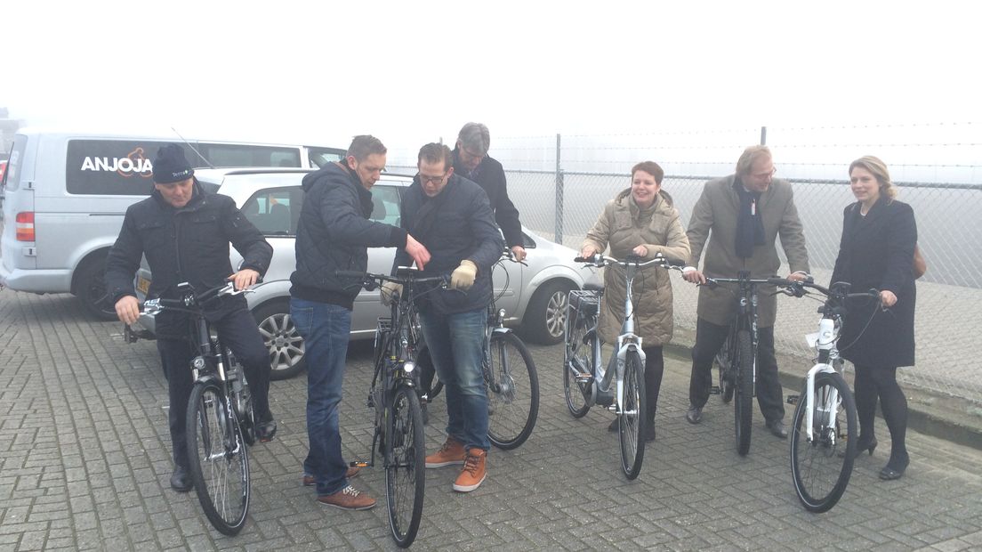 Gedeputeerde Henk Brink samen met Harmke Vlieg en collega's stappen op de elektrische fiets bij het TT-Circuit