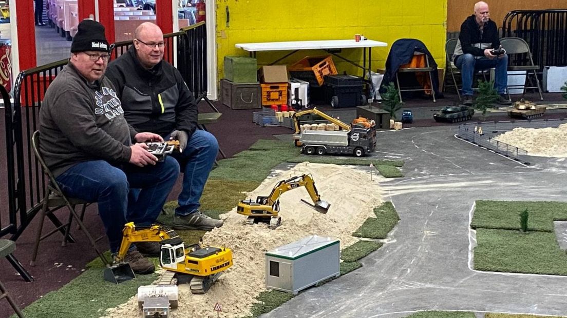 De broers John en Edwin van der Klok besturen hun modelhijskranen; rechtsboven doet Jan Meertens hetzelfde