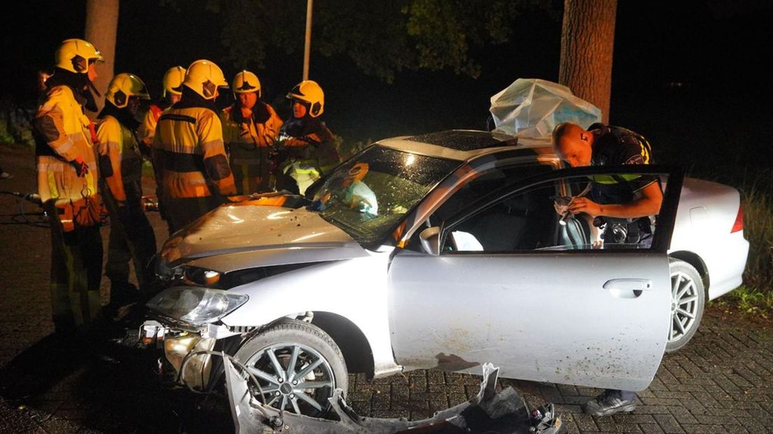 Hulpverleners bij de zwaar beschadigde auto in Ewijk.