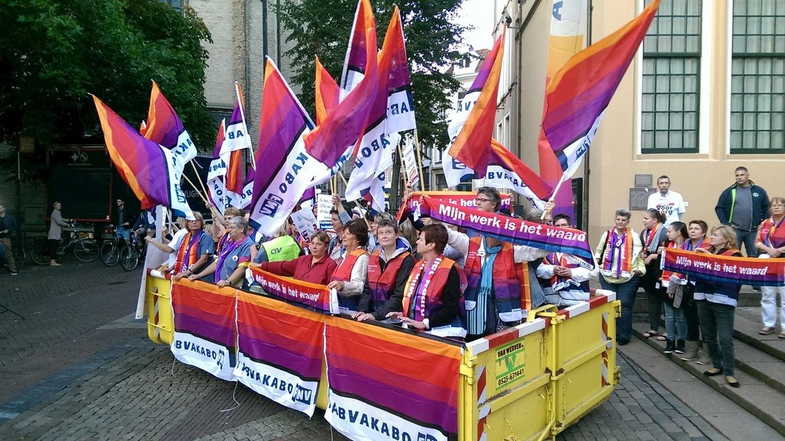 Een afvalcontainer vol met thuiszorgmedewerkers
