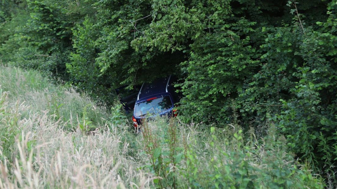 De auto is in de bosjes langs de weg beland