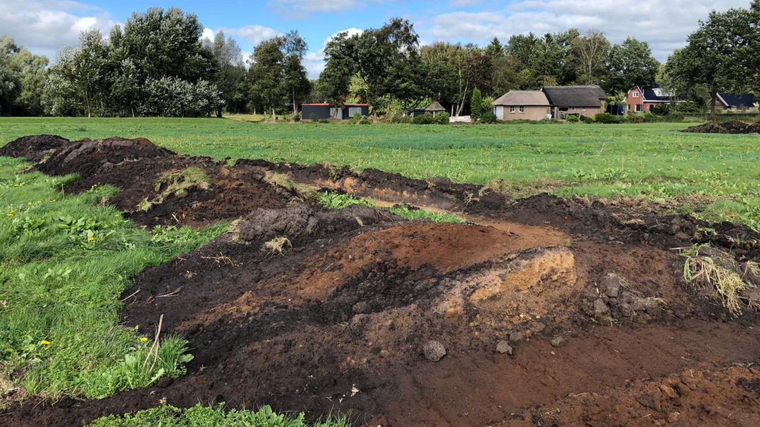 Donkere sporen in het gele zand wijzen op oude loopgraven