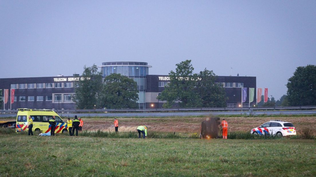 De hulpdiensten bezig bij de gecrashte wagen