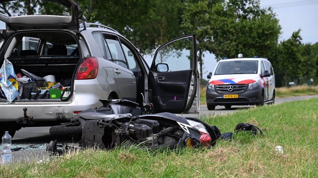 De scooterrijder botst achterop de auto in Blijham